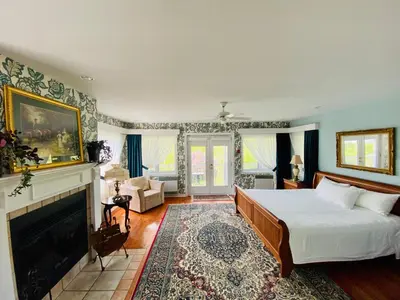 a bedroom with a bed and a fireplace at Auberge Le Tricorne in North Hatley