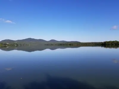 a view of a lake with mountains in the background at La Parade du Huard - Lac et Spa in Saint Sebastien