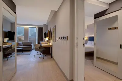 a hotel room with a desk and a bedroom at Hampton Inn Montreal Downtown, Qc in Montréal