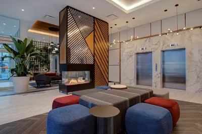 a lobby with a fireplace and a table and chairs at Hampton Inn Montreal Downtown, Qc in Montréal