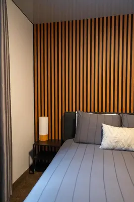 a bedroom with a bed and a striped wall at Au Sommet du Lac Magog in Magog-Orford