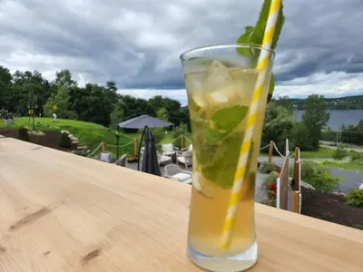 a glass with a drink on a wooden table at Au Sommet du Lac Magog in Magog-Orford