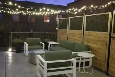a patio with two chairs and a table and lights at Plaza10 - 20 restaurants at under a 10 minute walk in Montréal
