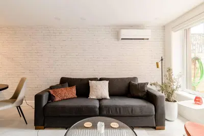 a living room with a couch and a brick wall at Plaza10 - 20 restaurants at under a 10 minute walk in Montréal