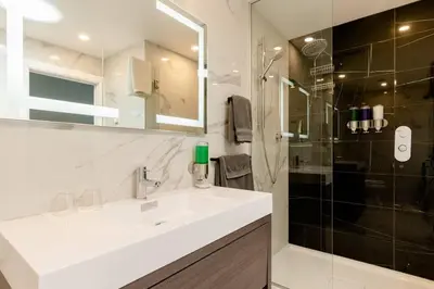 a bathroom with a white sink and a shower at Plaza12 - StringLights, XL Terrace, restos & shops in Montréal