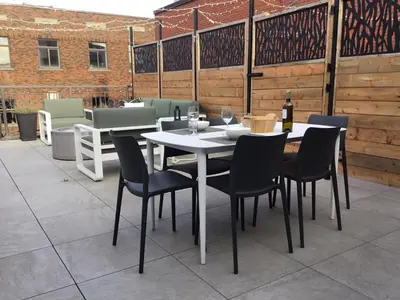 a white table and chairs on a patio at Plaza12 - StringLights, XL Terrace, restos & shops in Montréal
