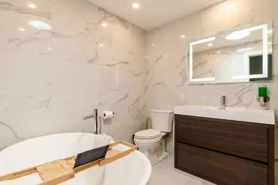 a bathroom with a tub and a toilet and a sink at Plaza12 - StringLights, XL Terrace, restos & shops in Montréal