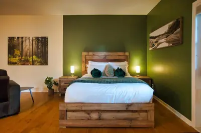 a bedroom with a bed and a green wall at Condo Hôtel Magog Orford in Orford