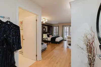 a room with a bedroom with a bed and a door at Condo Hôtel Magog Orford in Orford