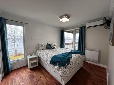 a bedroom with a bed and a window at Condos Memphrémagog in Magog-Orford
