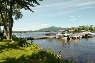 a group of boats docked at a dock on a lake at Condos Memphrémagog in Magog-Orford