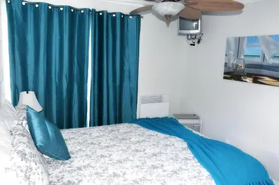 a bedroom with a bed with a blue curtain at Condos Memphrémagog in Magog-Orford