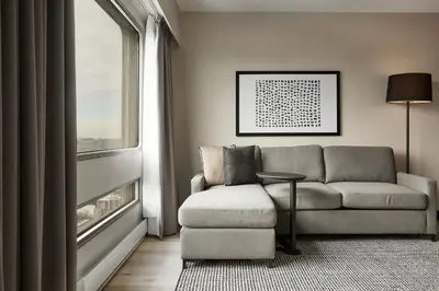 a living room with a couch and a window at Hyatt Place Montreal - Downtown in Montréal