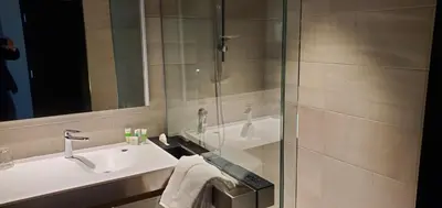 a bathroom with a sink and a glass shower at Grand Times Hotel Laval - Centropolis in Laval