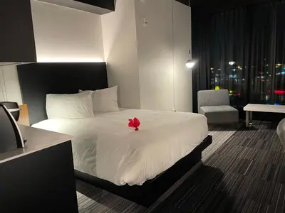 a bedroom with a bed with a red flower on it at Grand Times Hotel Laval - Centropolis in Laval