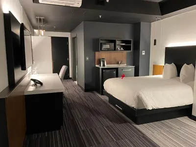 a hotel room with a bed and a desk at Grand Times Hotel Laval - Centropolis in Laval