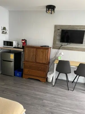 a room with a desk and a tv and a wooden dresser at Motel Valois YL inc in Acton Vale