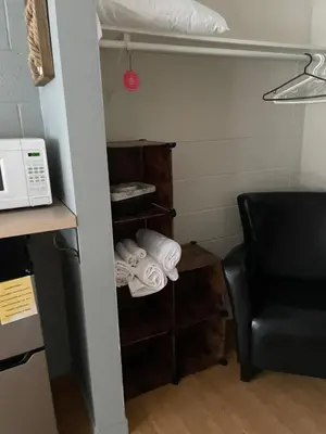 a room with a chair and a microwave and towels at Motel Valois YL inc in Acton Vale