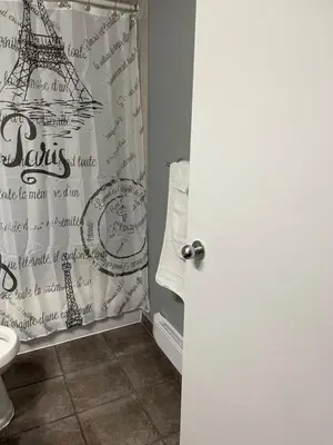a bathroom with a shower curtain with the eiffel tower at Motel Valois YL inc in Acton Vale