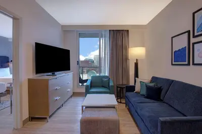 a living room with a couch and a flat screen tv at Homewood Suites By Hilton Montreal Downtown in Montréal