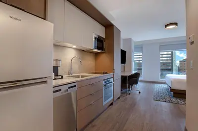 a kitchen with a sink and a desk in a room at Homewood Suites By Hilton Montreal Downtown in Montréal