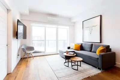 a living room with a couch and a table at Sleek Condo in the Heart of Little Italy by Den Stays in Montréal