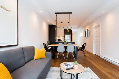 a living room with a couch and a table at Sleek Condo in the Heart of Little Italy by Den Stays in Montréal