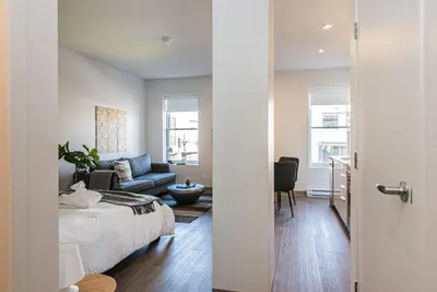 a bedroom and living room with a bed and a couch at New, Fresh and Luminous Studio in Le Plateau by Den Stays in Montréal