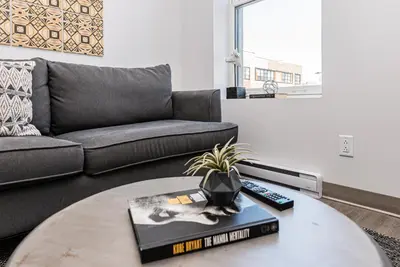 a living room with a couch and a table at New, Fresh and Luminous Studio in Le Plateau by Den Stays in Montréal