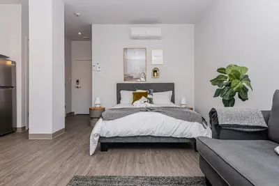 a bedroom with a bed and a couch at New, Fresh and Luminous Studio in Le Plateau by Den Stays in Montréal