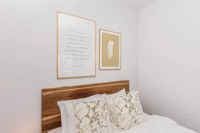 a bedroom with a bed with two pictures on the wall at Huge New Flat well Located closed on St-Denis Street by Den Stays in Montréal