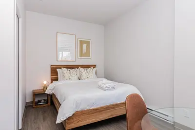 a bedroom with a bed and a glass table at Huge New Flat well Located closed on St-Denis Street by Den Stays in Montréal