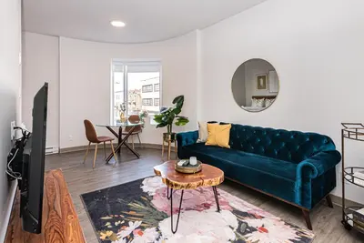 a living room with a green couch and a table at Huge New Flat well Located closed on St-Denis Street by Den Stays in Montréal