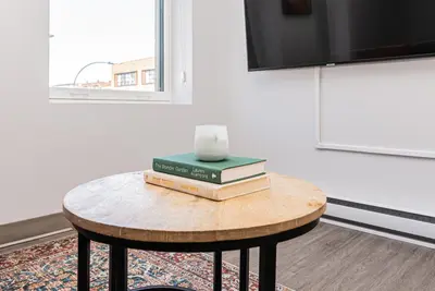 a table with books and a vase on top of it at Wonderful New Studio close to Mount Royal By Den Stays in Montréal