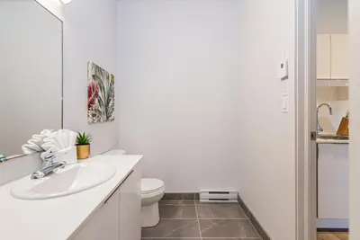 a white bathroom with a sink and a toilet at Wonderful New Studio close to Mount Royal By Den Stays in Montréal