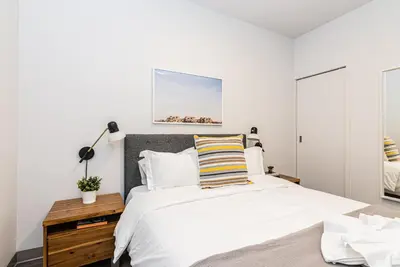 a bedroom with a large bed with a wooden night stand at New Urban and Well Located 1 Bedroom Apartment by Den Stays in Montréal