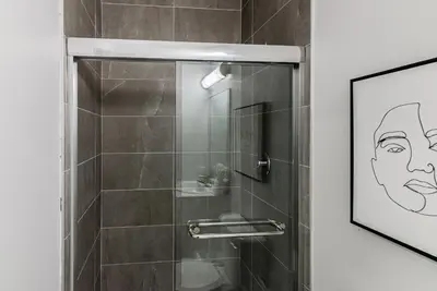 a bathroom with a shower with a picture of a man at New Urban and Well Located 1 Bedroom Apartment by Den Stays in Montréal