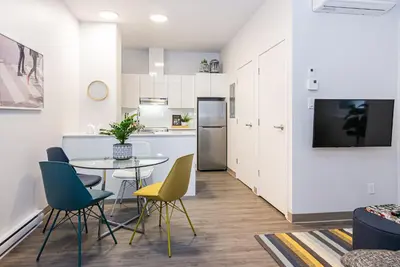 a kitchen and dining room with a table and chairs at New Urban and Well Located 1 Bedroom Apartment by Den Stays in Montréal
