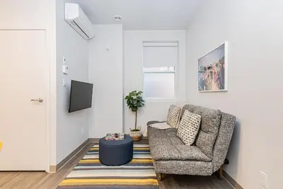 a living room with a chair and a rug at New Urban and Well Located 1 Bedroom Apartment by Den Stays in Montréal