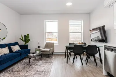 a living room with a blue couch and a table at Modern and New Studio in the Heart of the City by Den Stays in Montréal