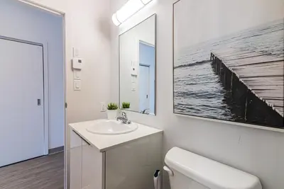 a bathroom with a toilet and a sink and a mirror at Modern and New Studio in the Heart of the City by Den Stays in Montréal