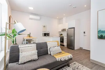 a living room with a couch and a kitchen at New and Perfectly Located 1 Bedroom Apartment by Den Stays in Montréal