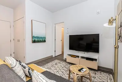 a living room with a couch and a tv at New and Perfectly Located 1 Bedroom Apartment by Den Stays in Montréal