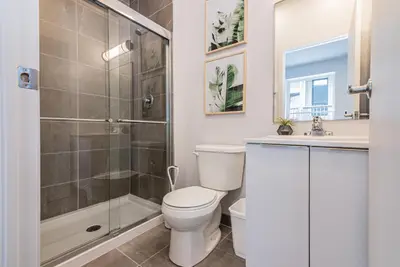 a bathroom with a shower and a toilet and a sink at New and Perfectly Located 1 Bedroom Apartment by Den Stays in Montréal