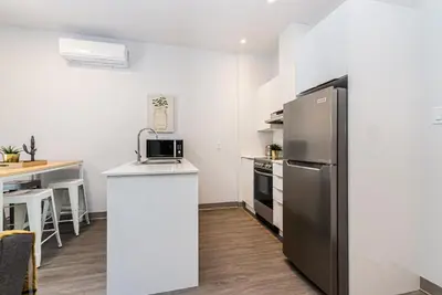 a kitchen with a stainless steel refrigerator and a counter at New and Perfectly Located 1 Bedroom Apartment by Den Stays in Montréal