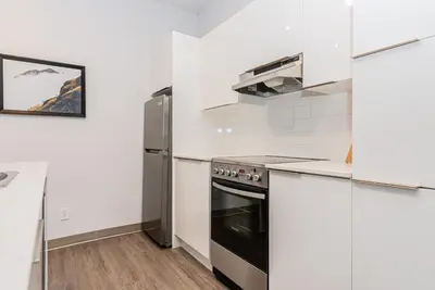 a kitchen with a stove and a refrigerator at Stylish & Fun 1 Bedroom Apartment in Le Plateau by Den Stays in Montréal