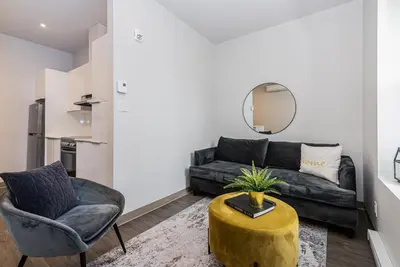 a living room with a couch and a chair at Stylish & Fun 1 Bedroom Apartment in Le Plateau by Den Stays in Montréal