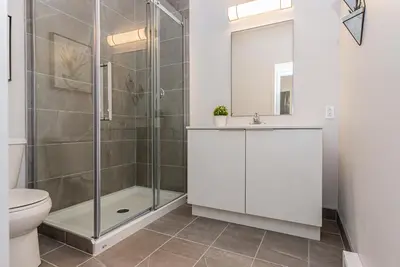 a bathroom with a shower and a toilet and a sink at Stylish & Fun 1 Bedroom Apartment in Le Plateau by Den Stays in Montréal