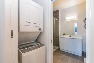 a bathroom with a washing machine and a sink at Stylish & Fun 1 Bedroom Apartment in Le Plateau by Den Stays in Montréal