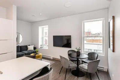 a kitchen and living room with a table and chairs at Stylish & Fun 1 Bedroom Apartment in Le Plateau by Den Stays in Montréal